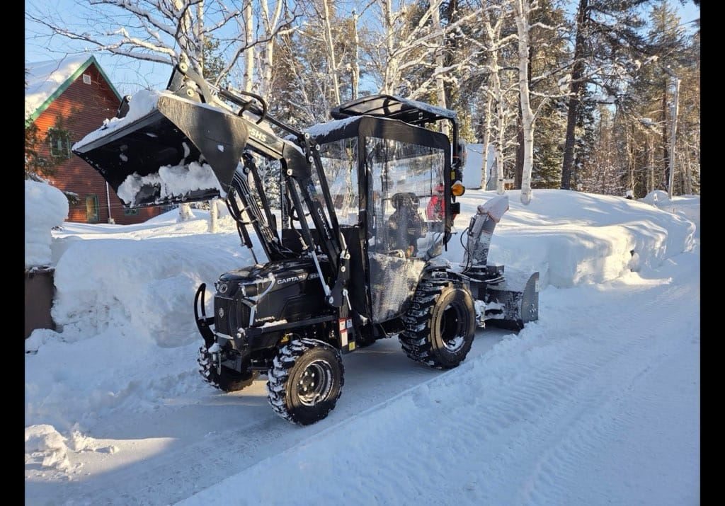 Captain tractor with 40 inch Bercomac winter cab clearing snow