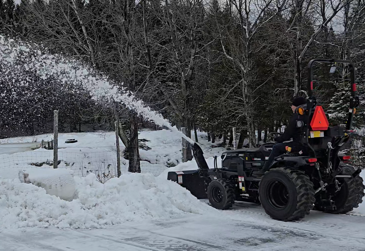 Captain 2532 tractor blowing snow across a driveway